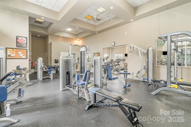 workout area featuring ceiling fan, coffered ceiling, and a towering ceiling