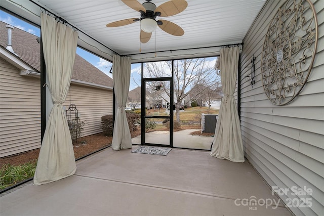 unfurnished sunroom featuring ceiling fan and plenty of natural light