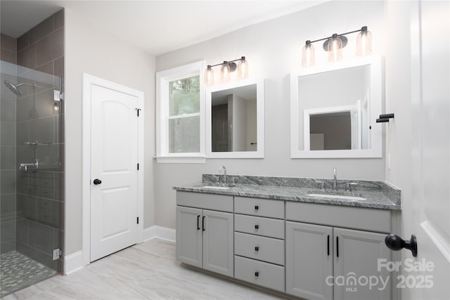 bathroom featuring a shower with shower door and vanity