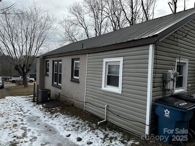 snow covered property with central AC unit