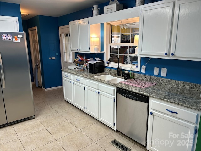 kitchen with sink, dark stone counters, white cabinets, and appliances with stainless steel finishes