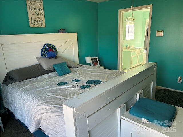 carpeted bedroom featuring sink and ensuite bathroom