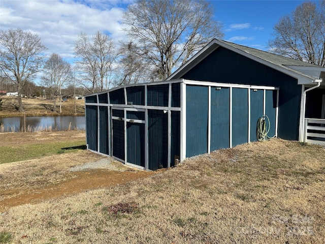 view of outdoor structure featuring a lawn and a water view