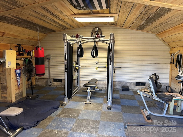 workout area featuring wooden walls, vaulted ceiling, and wood ceiling