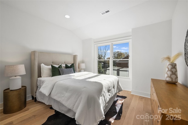 bedroom featuring vaulted ceiling and light hardwood / wood-style floors