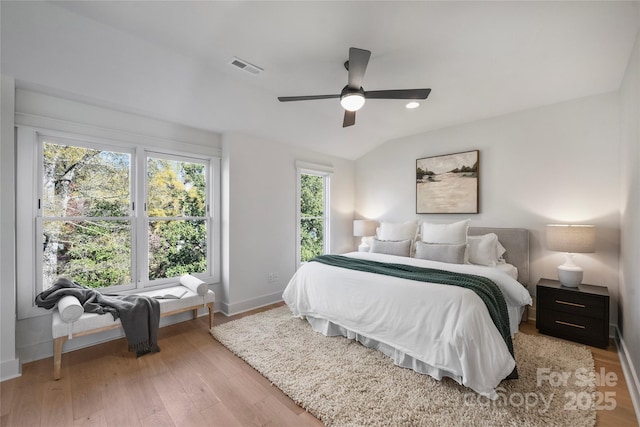 bedroom with ceiling fan, vaulted ceiling, and light hardwood / wood-style flooring