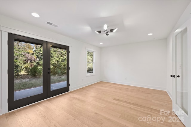 empty room with light wood-type flooring and french doors