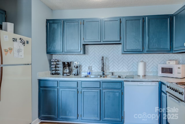 kitchen with a textured ceiling, white appliances, tasteful backsplash, sink, and blue cabinets