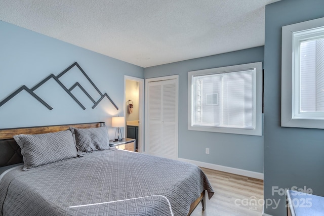 bedroom with light wood-type flooring, a closet, and a textured ceiling