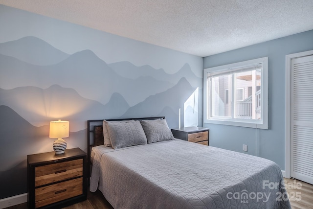 bedroom featuring a textured ceiling and dark wood-type flooring