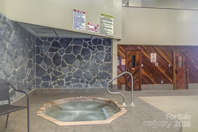 interior space with tile patterned floors and wood walls