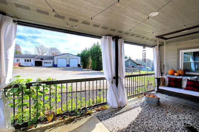 view of patio / terrace with a garage and an outbuilding