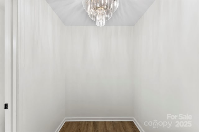 spacious closet featuring a notable chandelier and dark hardwood / wood-style floors