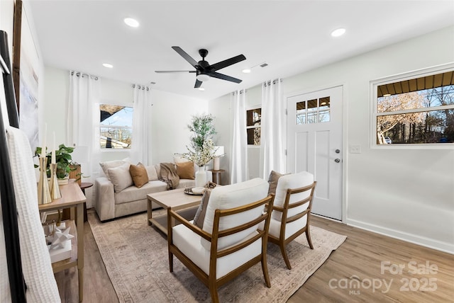 living room with light hardwood / wood-style floors and ceiling fan