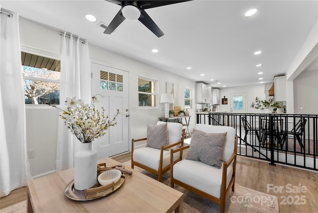 sitting room with ceiling fan and light hardwood / wood-style floors