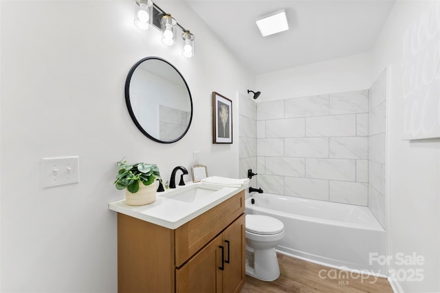 full bathroom featuring toilet, tiled shower / bath combo, hardwood / wood-style floors, and vanity