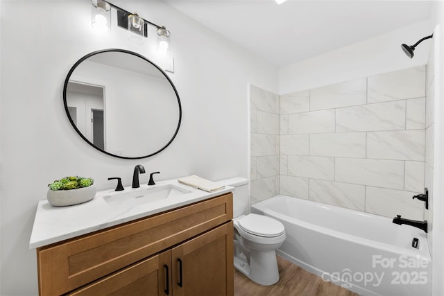 full bathroom featuring toilet, tiled shower / bath combo, hardwood / wood-style flooring, and vanity