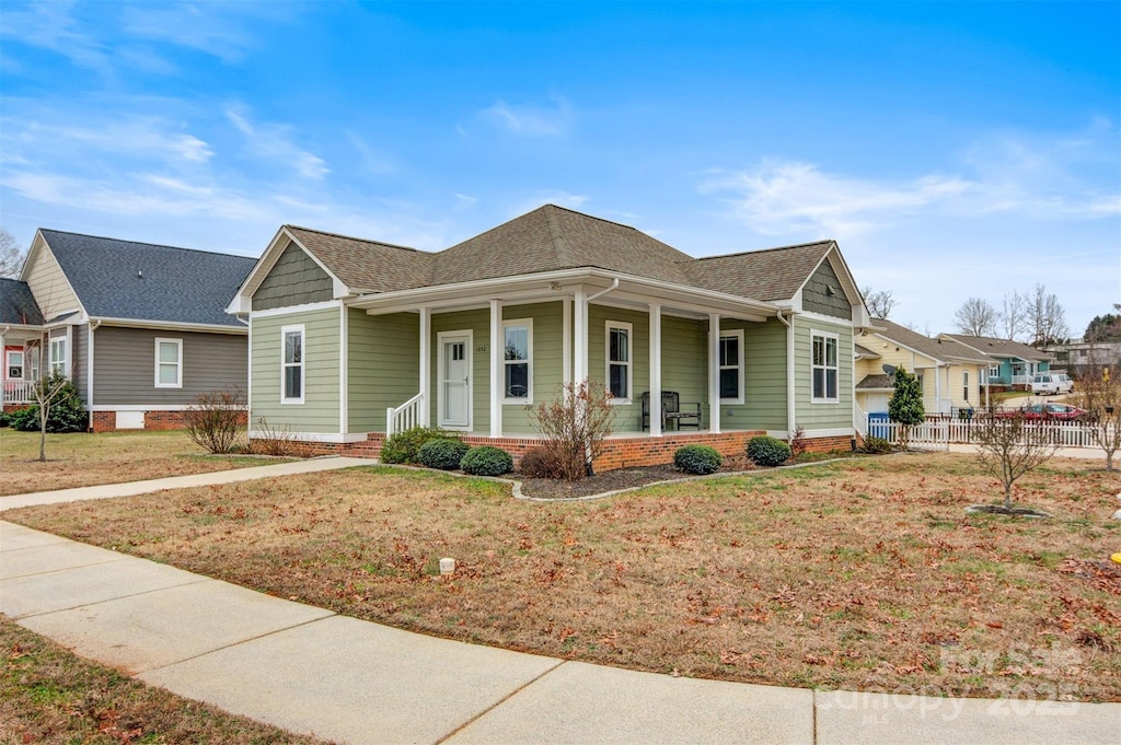 view of front of house featuring covered porch and a front yard