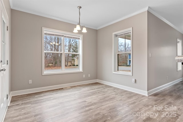 unfurnished dining area featuring a chandelier, light hardwood / wood-style flooring, a wealth of natural light, and ornamental molding