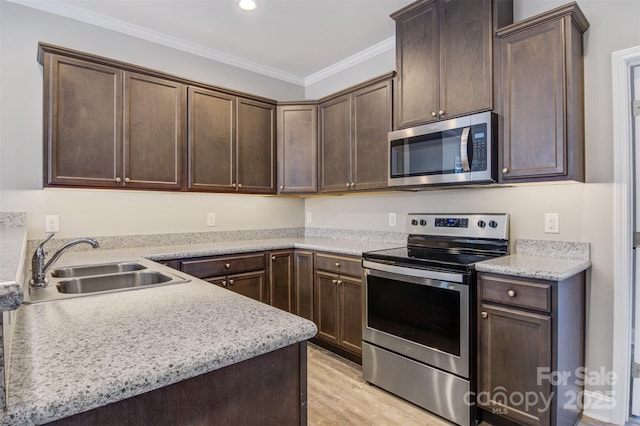 kitchen featuring dark brown cabinets, sink, ornamental molding, light hardwood / wood-style floors, and stainless steel appliances