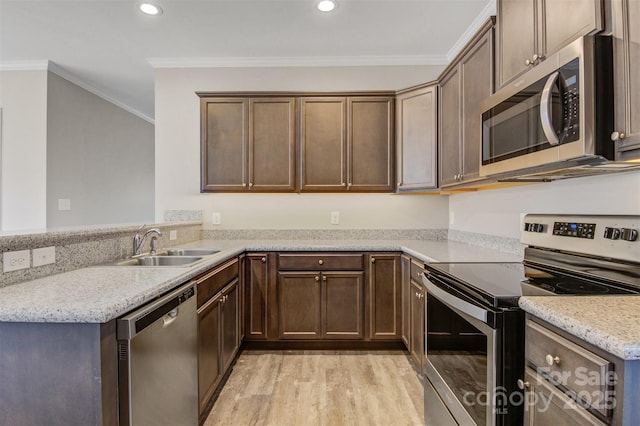 kitchen featuring crown molding, light stone countertops, appliances with stainless steel finishes, light wood-type flooring, and sink