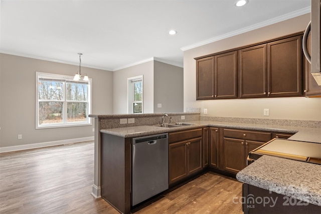 kitchen with kitchen peninsula, appliances with stainless steel finishes, sink, light stone counters, and ornamental molding