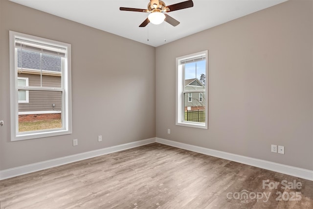 empty room with ceiling fan and light hardwood / wood-style flooring