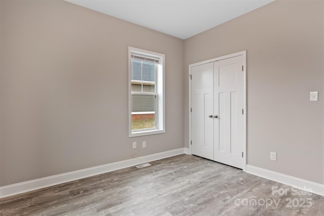 unfurnished bedroom featuring light hardwood / wood-style floors and a closet