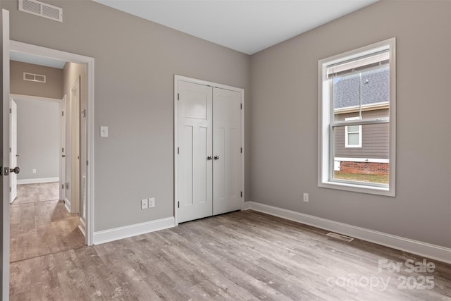 unfurnished bedroom featuring light hardwood / wood-style floors and a closet