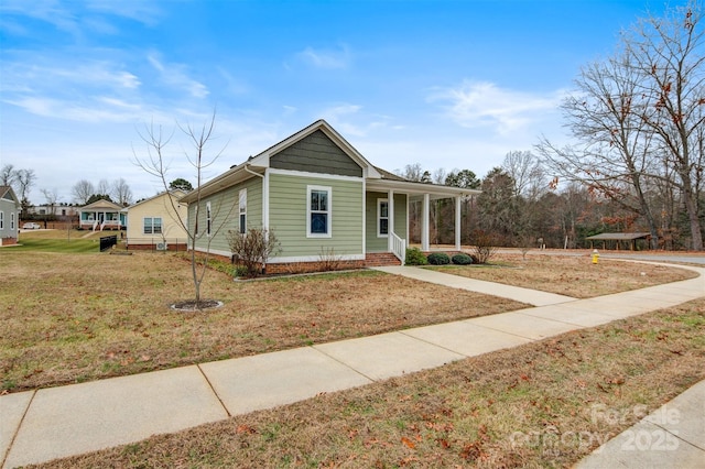 view of front of home featuring covered porch and a front yard