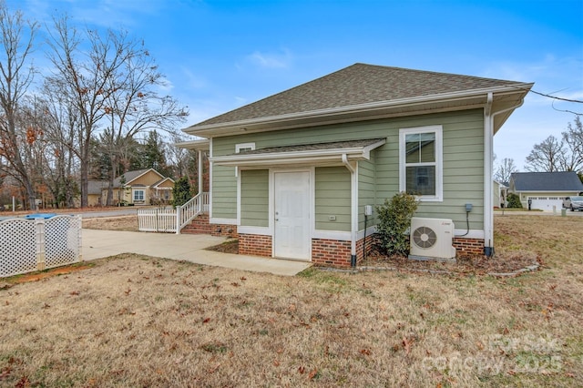 rear view of property featuring ac unit, a yard, and a patio