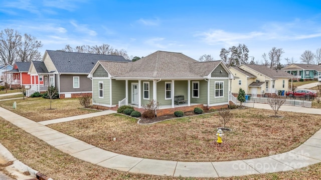 view of front of house featuring a porch, a garage, and a front lawn