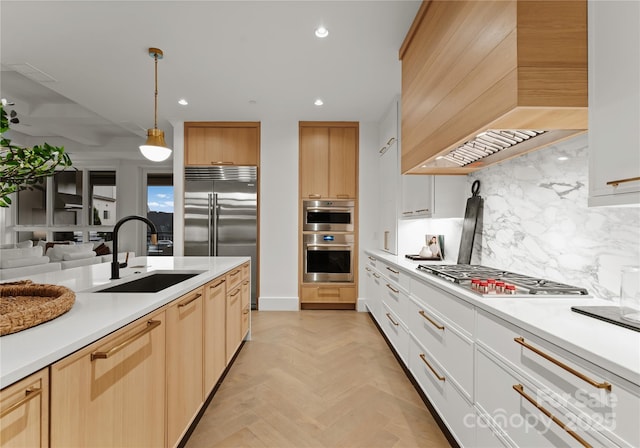 kitchen featuring pendant lighting, decorative backsplash, sink, custom range hood, and white cabinets