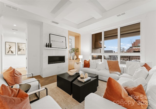 living room with beam ceiling, coffered ceiling, and light hardwood / wood-style flooring