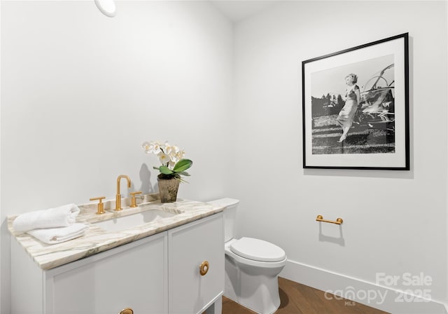 bathroom with toilet, wood-type flooring, and vanity