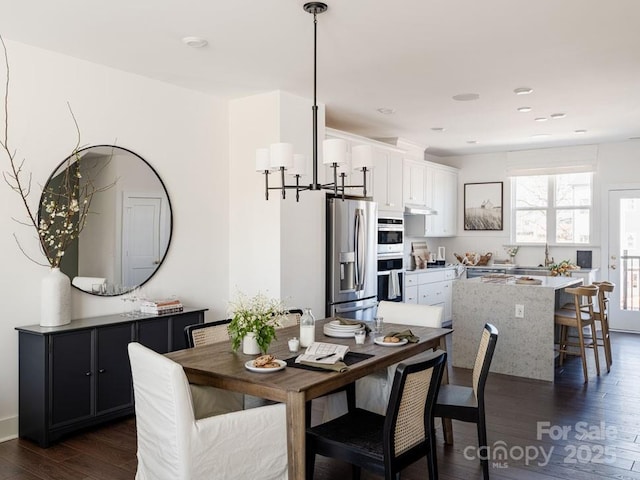 dining area featuring an inviting chandelier and dark wood finished floors