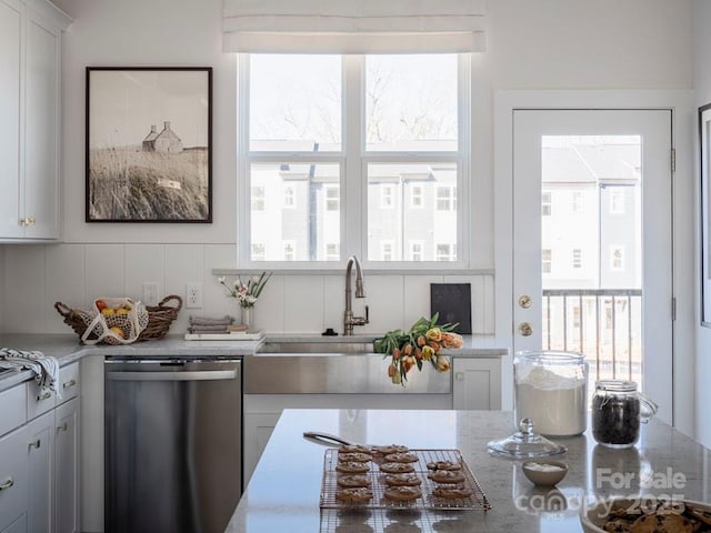 kitchen with a healthy amount of sunlight, dishwasher, and white cabinetry