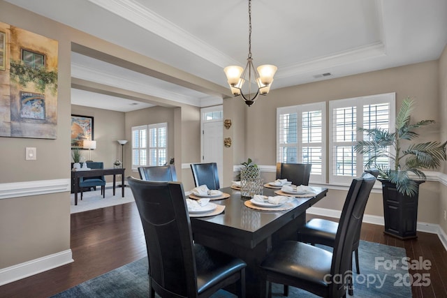 dining room with a raised ceiling, a notable chandelier, dark hardwood / wood-style flooring, and crown molding