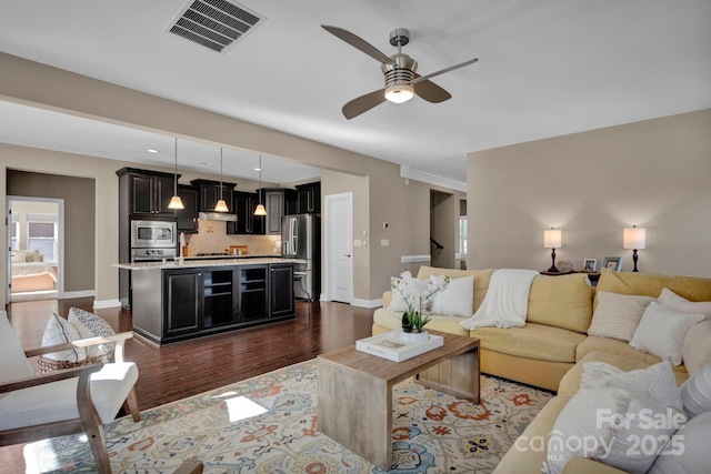 living room featuring ceiling fan and dark hardwood / wood-style flooring