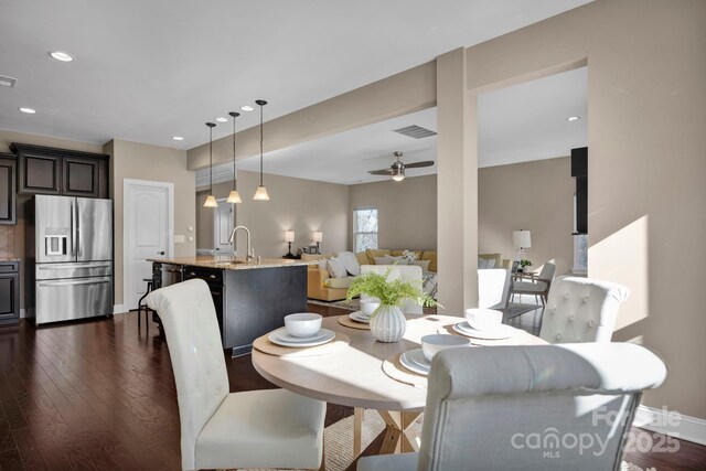 dining area with dark wood-type flooring, ceiling fan, and sink