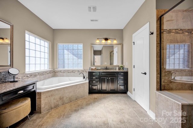 bathroom featuring vanity, tile patterned flooring, and plus walk in shower