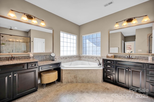 bathroom with tile patterned flooring, vanity, and plus walk in shower