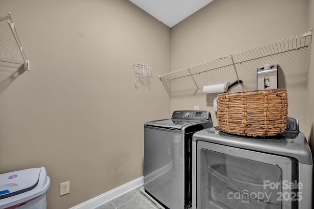 washroom featuring washer and clothes dryer and light tile patterned flooring