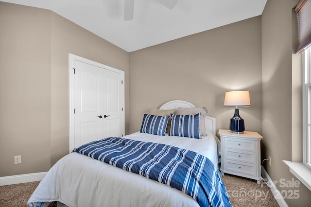 carpeted bedroom with ceiling fan and a closet