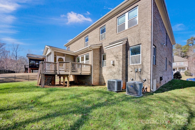 rear view of house featuring a deck, cooling unit, and a yard