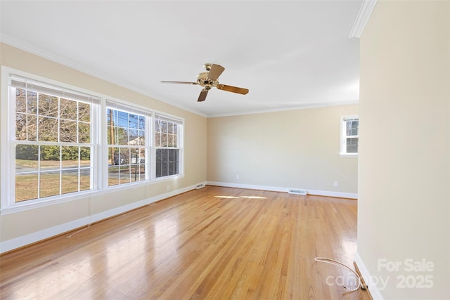 empty room with ceiling fan, ornamental molding, and light hardwood / wood-style flooring