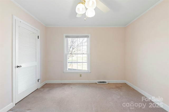 unfurnished room featuring ceiling fan, ornamental molding, and light colored carpet