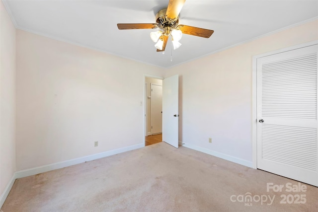 carpeted empty room featuring ceiling fan and ornamental molding