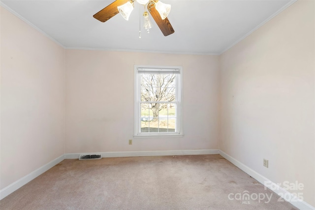 spare room featuring ceiling fan, crown molding, and light carpet