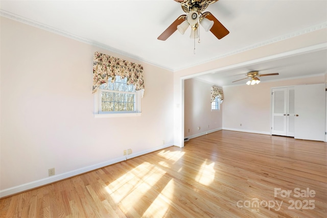 empty room with ceiling fan, a healthy amount of sunlight, crown molding, and hardwood / wood-style floors